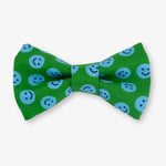 Green bow tie with blue smiley face pattern on a white background
