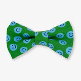 Green bow tie with blue smiley face pattern on a white background
