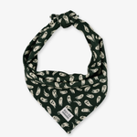 A dark green pet bandana featuring a repeating pattern of white ghosts, tied at the top and shown on a light gray background. A small white brand label reading 'POUSER' is visible near the bottom corner.