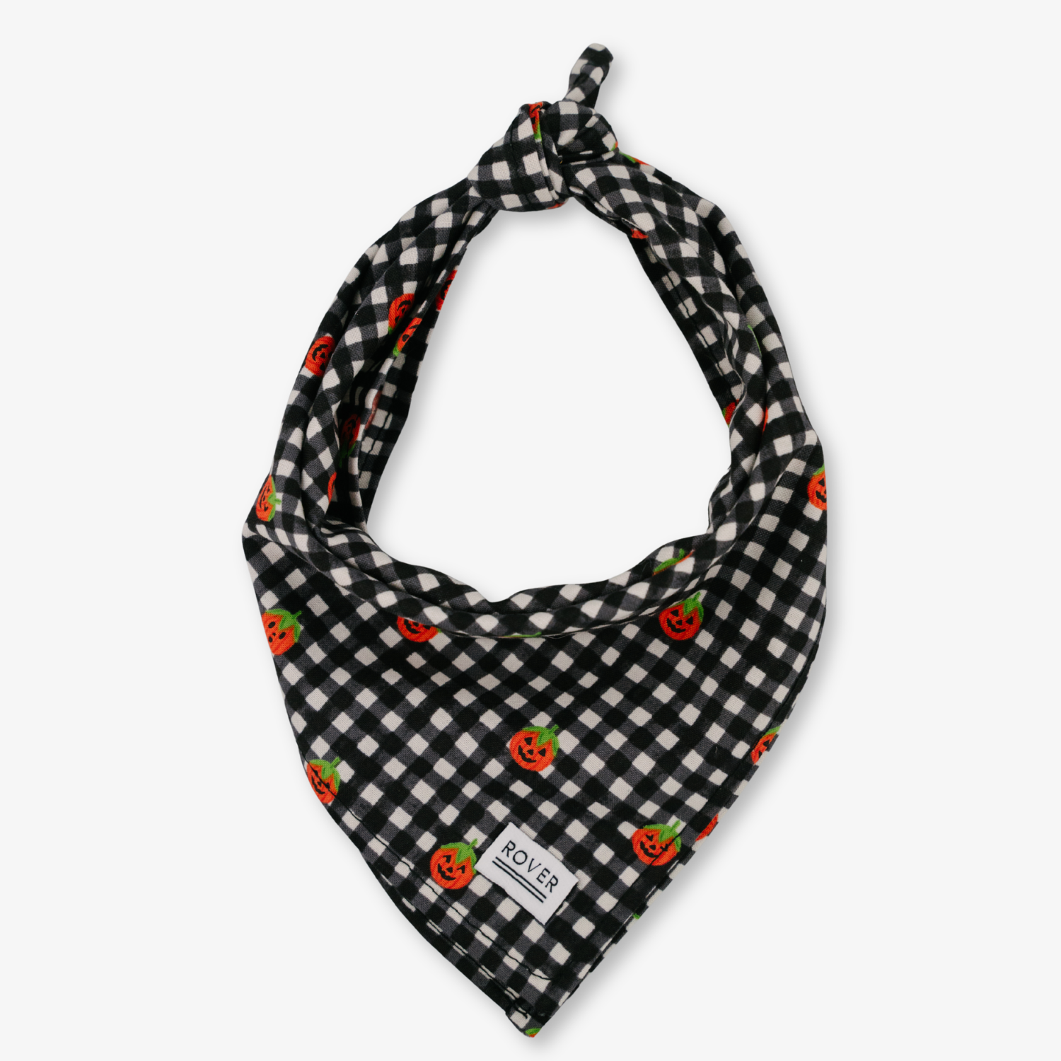 A black bandana-style pet scarf with a knotted top corner, featuring a colorful Halloween-themed print with white ghosts, a skeleton, stars, candy corn, a spiderweb, and a moon. A small white fabric tag near the bottom reads 'POLICE'.