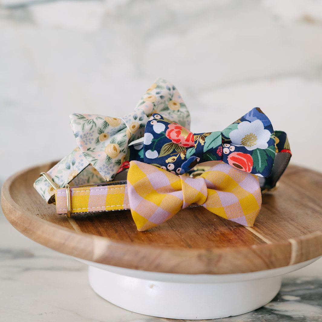 Colorful bow ties on a wooden stand with a marble background